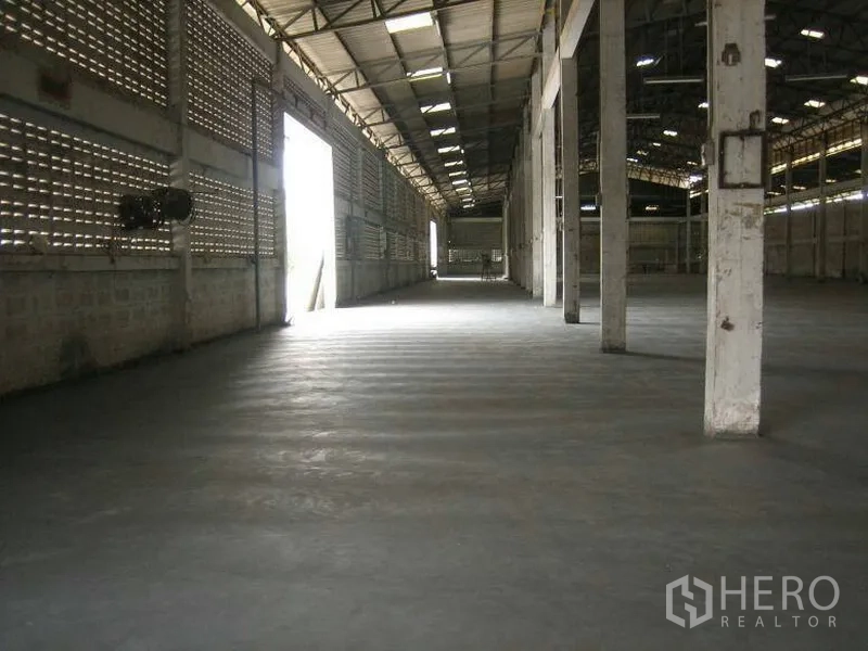 Warehouse for rent in Min Buri, Bangkok - Spacious warehouse interior with high steel roof, concrete flooring, skylights and support columns in Min Buri, Bangkok.