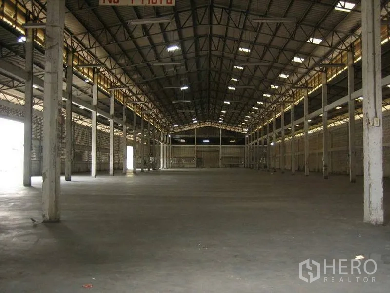 Warehouse for rent in Min Buri, Bangkok - Open-plan warehouse hall with high truss ceiling, ample lighting and a regular column grid.
