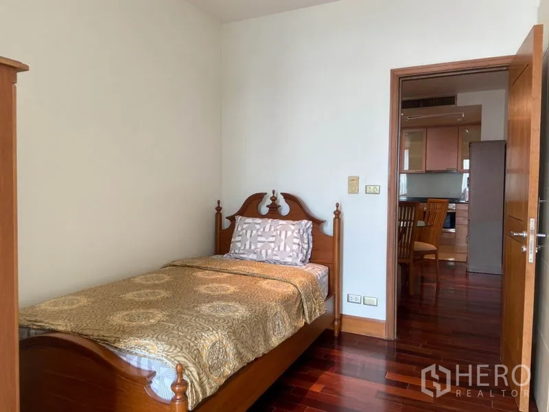 公寓 出租在Sathon, Bangkok - 单人卧室从门口望向厨房，木质床架与亮泽地板。