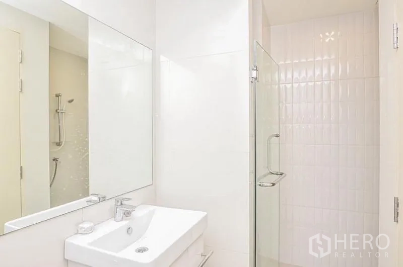 คอนโด ให้เช่าในDin Daeng, Bangkok - ห้องน้ำโทนขาว กระจกบานใหญ่ อ่างล้างหน้า และห้องอาบน้ำกระจก