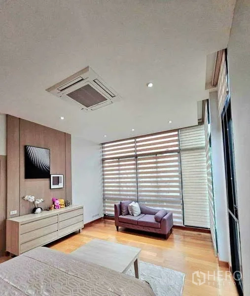 บ้าน ขายในKhlong Sam Wa, Bangkok - มุมพักผ่อนในห้องนอน โซฟาเดย์เบดข้างมู่ลี่ซ้อนชั้นสไตล์มินิมอล