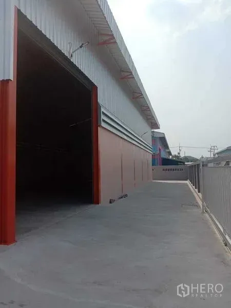 Warehouse for rent in Pathum Thani - Side elevation of the warehouse showing covered loading area and truck-friendly driveway.