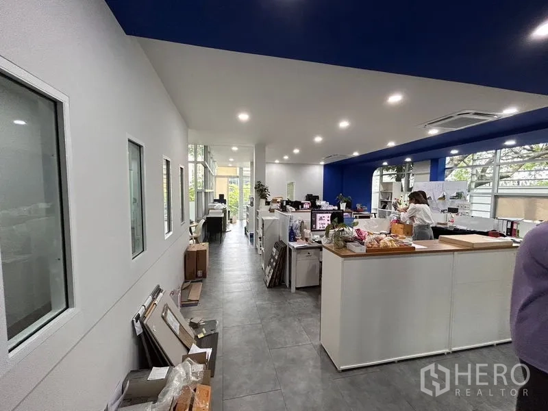 Office Space for rent in Khlong Toei, Bangkok - Long office zone with recessed ceiling lights, cabinetry and large side windows bringing in natural light.