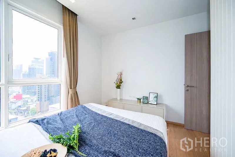 公寓 出租在Watthana, Bangkok - 卧室一角，转角窗与低矮收纳柜。