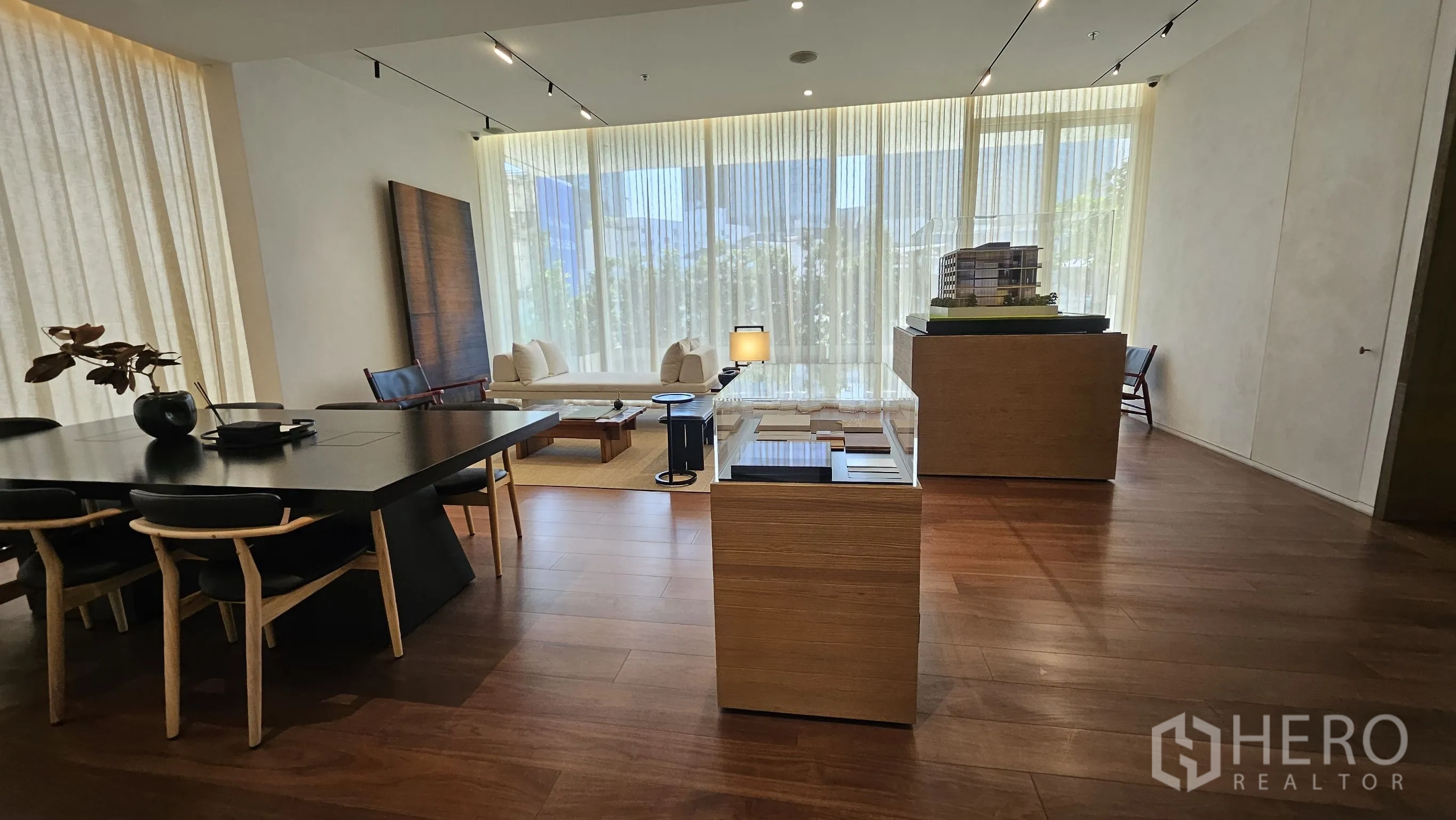 ออฟฟิศ for rent in Watthana, Bangkok - มุมมองกว้างของสำนักงาน มีโซนรับแขก แท่นจัดแสดง และผนังกระจกยาว.