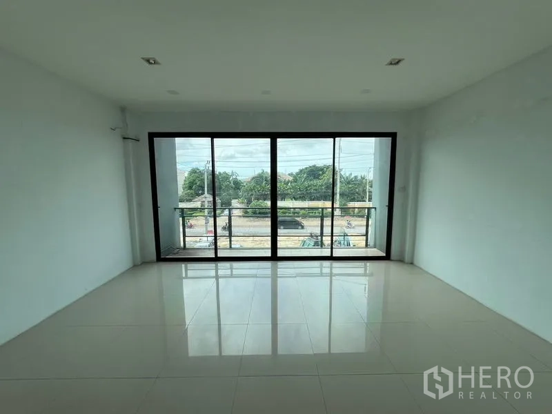 Warehouse for rent in Bang Phli, Samut Prakan - Bright office room with floor-to-ceiling sliding glass doors opening to a small balcony and street view.