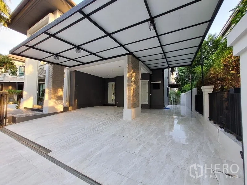 Detached House for rent in Bang Khae, Bangkok - Covered multi-car carport with tiled floor and black metal canopy.