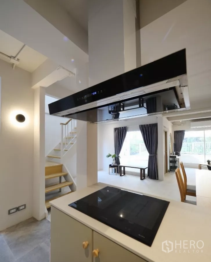 联排别墅 出租或出售在Watthana, Bangkok - 现代厨房岛台，电磁炉与烟机，面向客餐一体空间。