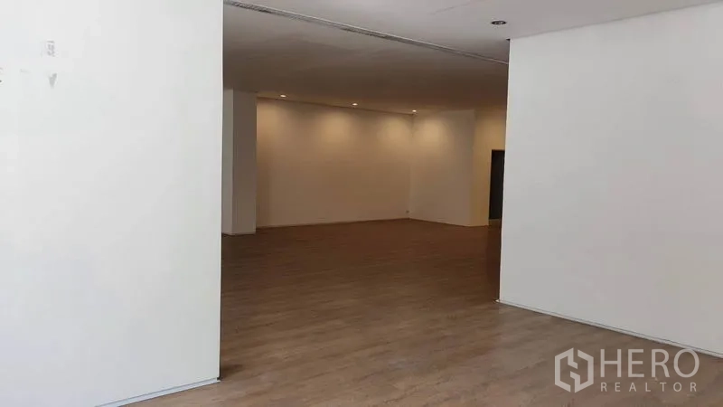 零售空间 出租在Khlong Toei, Bangkok - 店内深进空间通向后区，射灯照明与白色墙面。