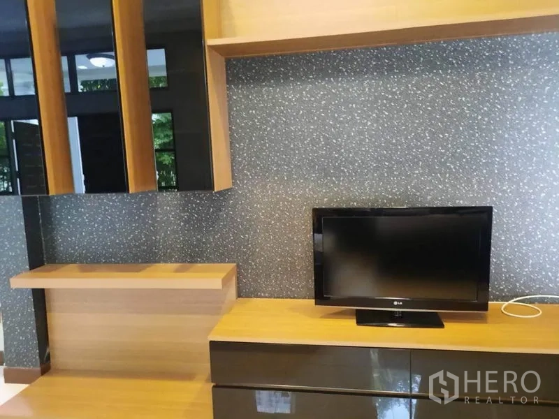 Detached House for rent in Khlong Toei, Bangkok - Built-in media wall with wood shelving and a flat-screen TV.