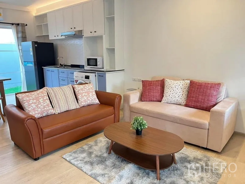 联排别墅 出租在Prawet, Bangkok - 开放式起居区，双沙发与茶几，毗邻厨房用餐区。