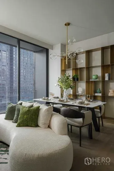 Condominium for rent - Contemporary living and dining area with curved sofa, marble dining table, glass chandelier and floor‑to‑ceiling windows overlooking the city.