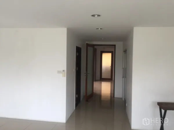 Townhouse for rent in Bang Rak, Bangkok - Bright hallway with recessed lights, white walls and glossy tile floors in a Bangkok townhouse.
