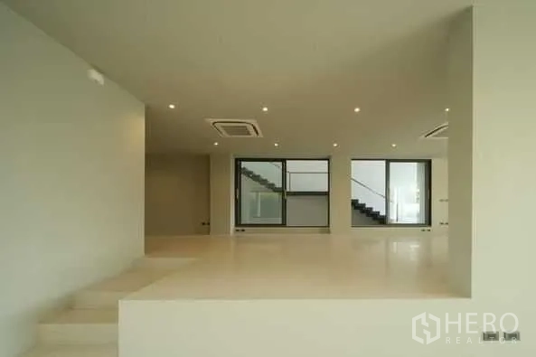 Home Office for sale in Wang Thonglang, Bangkok - Raised platform open-plan area with downlights and sliding glass doors beside staircase.