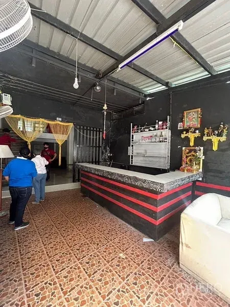 店屋 出租在Khlong Toei, Bangkok - 底层零售区，带长吧台、花纹地砖、深色墙面和裸露金属天花。