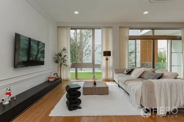 บ้าน ให้เช่าในSaphan Sung, Bangkok - ห้องนั่งเล่นสว่าง ผนังกระจกเต็มบาน โซฟา และวิวสวน