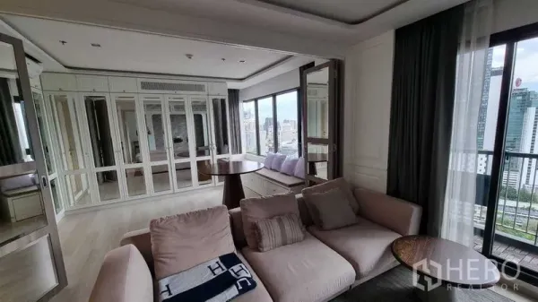 Condominium for sale in Pathum Wan, Bangkok - Cozy lounge with mirrored wall cabinets, round table and wide windows