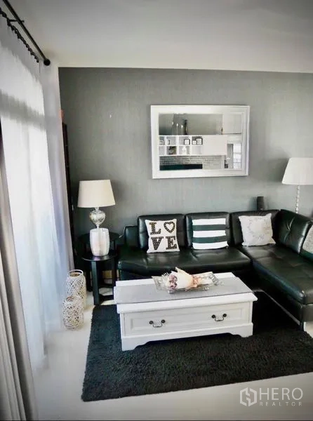 Detached House for rent or sale in Bang Phli, Samut Prakan - Cozy living room with black leather sectional, white coffee table and large window