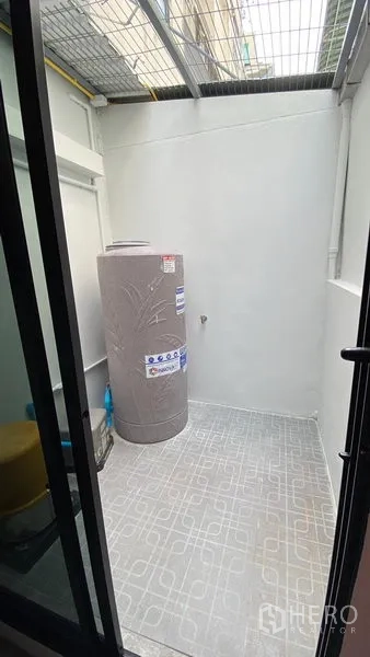 联排别墅 出租在Bang Na, Bangkok - 带金属顶的后院工作阳台，设蓄水箱与地砖。