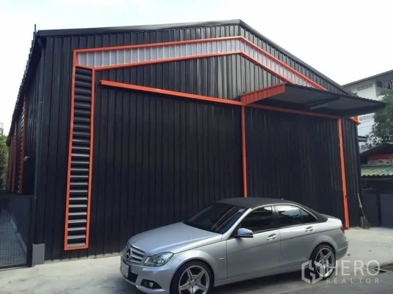Warehouse for rent in Lat Phrao, Bangkok - Warehouse exterior with large sliding entrance and a small canopy.