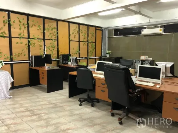 Warehouse for rent in Chatuchak, Bangkok - Open-plan office room with desks, computers and tiled flooring inside the warehouse.