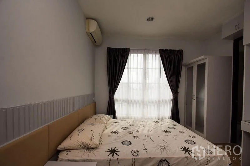 Condominium for rent in Khlong Toei, Bangkok - Cozy bedroom with double bed, wardrobe, and curtained window.