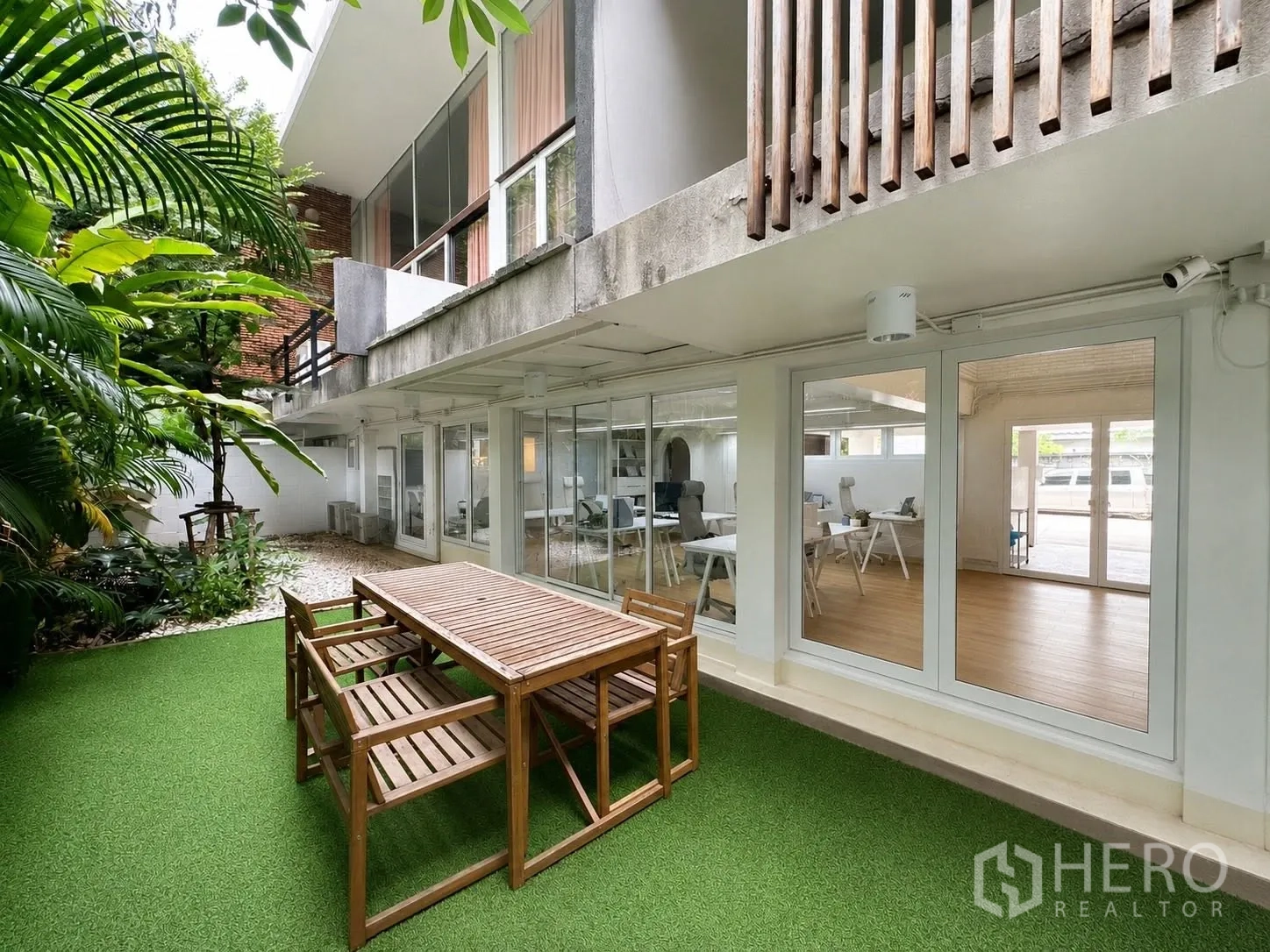 Office Space for rent in Phaya Thai, Bangkok - Garden patio with wooden outdoor table beside glass doors to the office.
