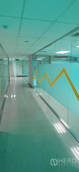 Office Space for rent in Huai Khwang, Bangkok - Glass-walled corridor with a yellow zigzag graphic and overhead lighting.