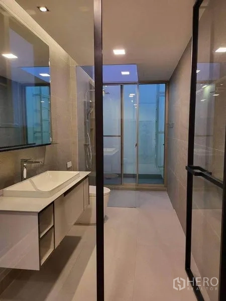 บ้าน ให้เช่าในSaphan Sung, Bangkok - ห้องน้ำโมเดิร์น เคาน์เตอร์ลอย กระจกบานใหญ่ และตู้กระจกอาบน้ำ โทนสีอบอุ่น