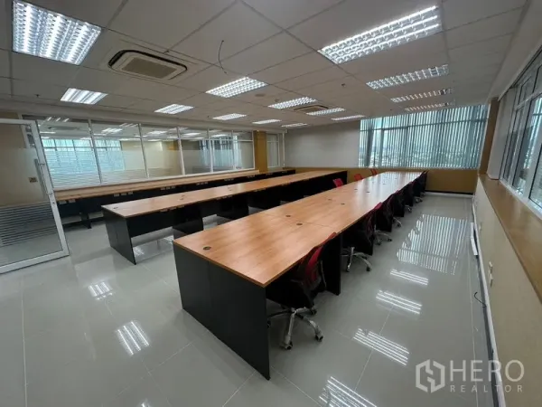 Office Space for rent in Suan Luang, Bangkok - Open-plan 80 sqm office with long wooden workstations, red task chairs, window blinds and air-conditioning in Suan Luang, Bangkok.