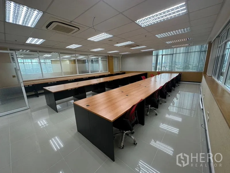 Office Space for rent in Suan Luang, Bangkok - Open-plan 80 sqm office with long wooden workstations, red task chairs, window blinds and air-conditioning in Suan Luang, Bangkok.