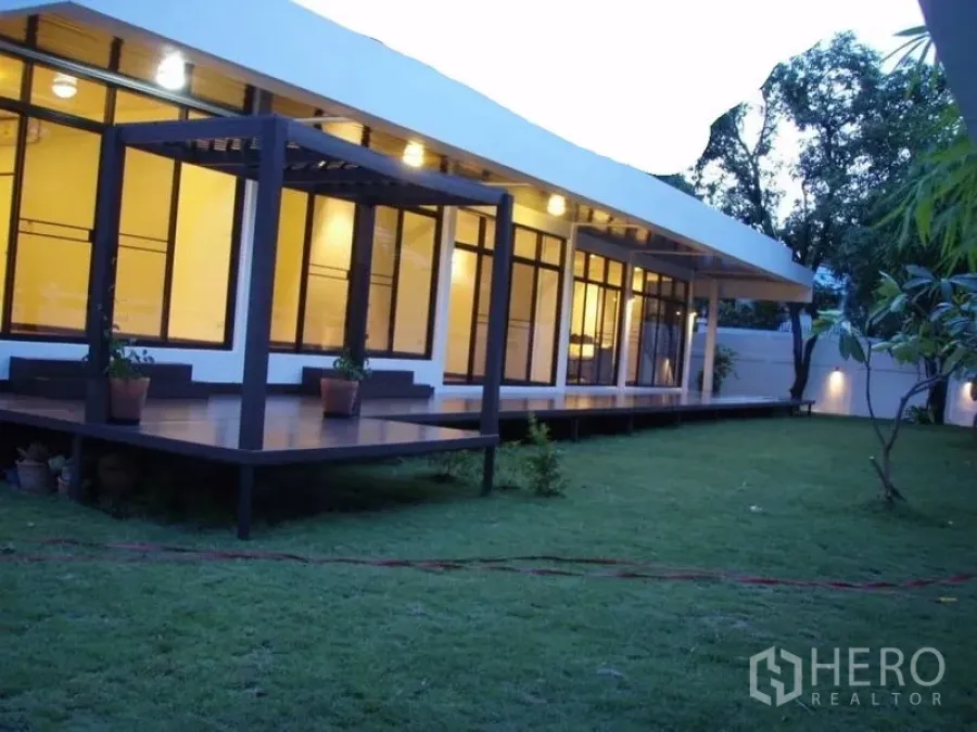 บ้าน ให้เช่าในHuai Khwang, Bangkok - ระเบียงยาวพร้อมศาลาไม้ มองออกไปยังสนามหญ้ากว้างรอบบ้าน