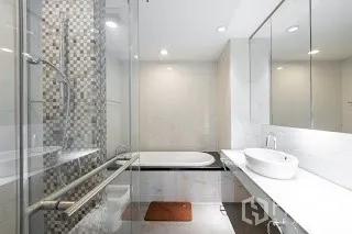 Condominium for rent in Bang Rak, Bangkok - Contemporary bathroom with glass shower, soaking tub and long vanity with mirror.