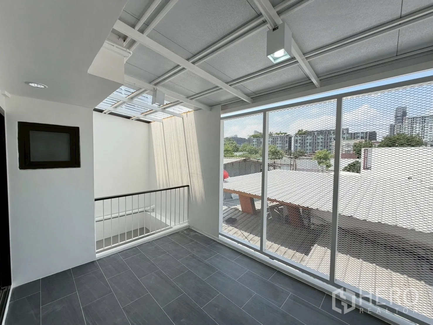 联排别墅 for sale in Phra Khanong, Bangkok - 半露台铺砖地，金属网屏，可观低层建筑景。