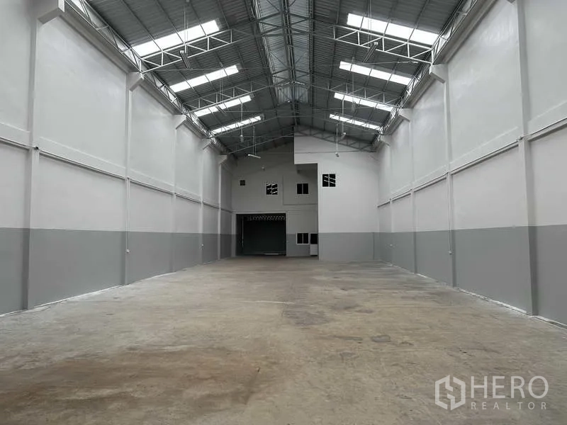 โรงงาน ให้เช่าในNonthaburi - มุมมองยาวของโกดังสว่างจากช่องแสงหลังคา พร้อมพื้นที่ใช้งานกว้าง
