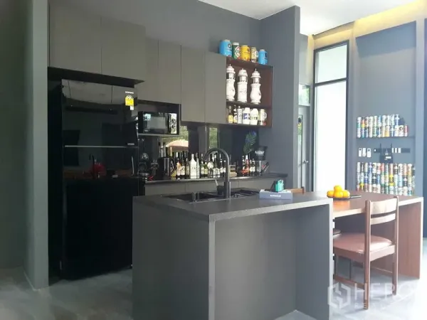 บ้าน ให้เช่าหรือขายในLam Luk Ka, Pathum Thani - แพนทรีครัวสไตล์โมเดิร์นโทนเข้ม มีไอส์แลนด์ อ่างล้างจาน เครื่องใช้ไฟฟ้าสีดำ และมุมทานอาหารเล็ก