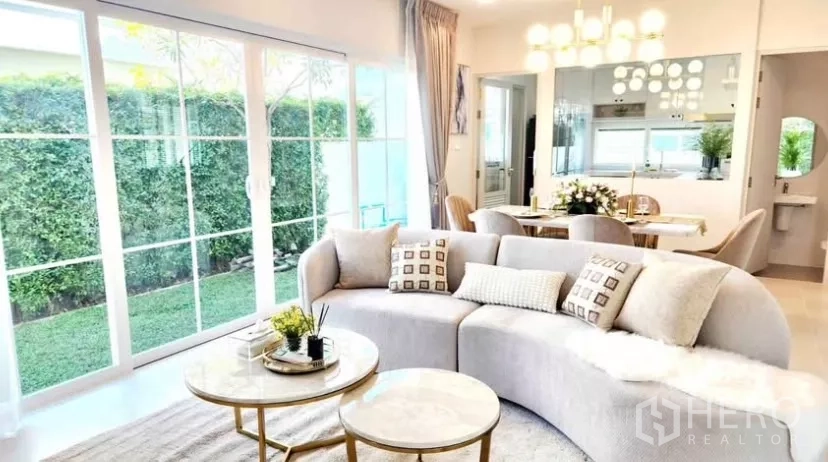 Detached House for rent in Bang Phli, Samut Prakan - Open-plan living area with garden views through full-height sliding doors.