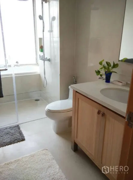 คอนโด ให้เช่าหรือขายในKhlong Toei, Bangkok - ห้องน้ำโมเดิร์น มีฝักบัวกั้นกระจก อ่างอาบน้ำริมหน้าต่าง เคาน์เตอร์อ่างล้างหน้าบานไม้ และโถสุขภัณฑ์