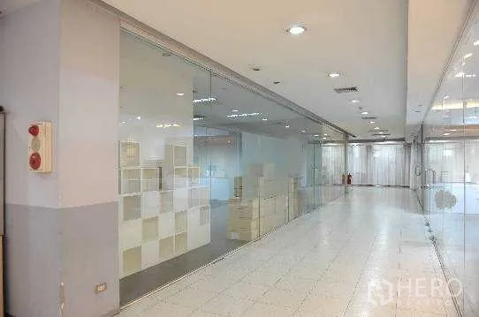 สำนักงาน ให้เช่าในKhlong Toei, Bangkok - มุมทางเดินเห็นผนังกระจกเต็มบานของออฟฟิศและพื้นกระเบื้องสว่าง
