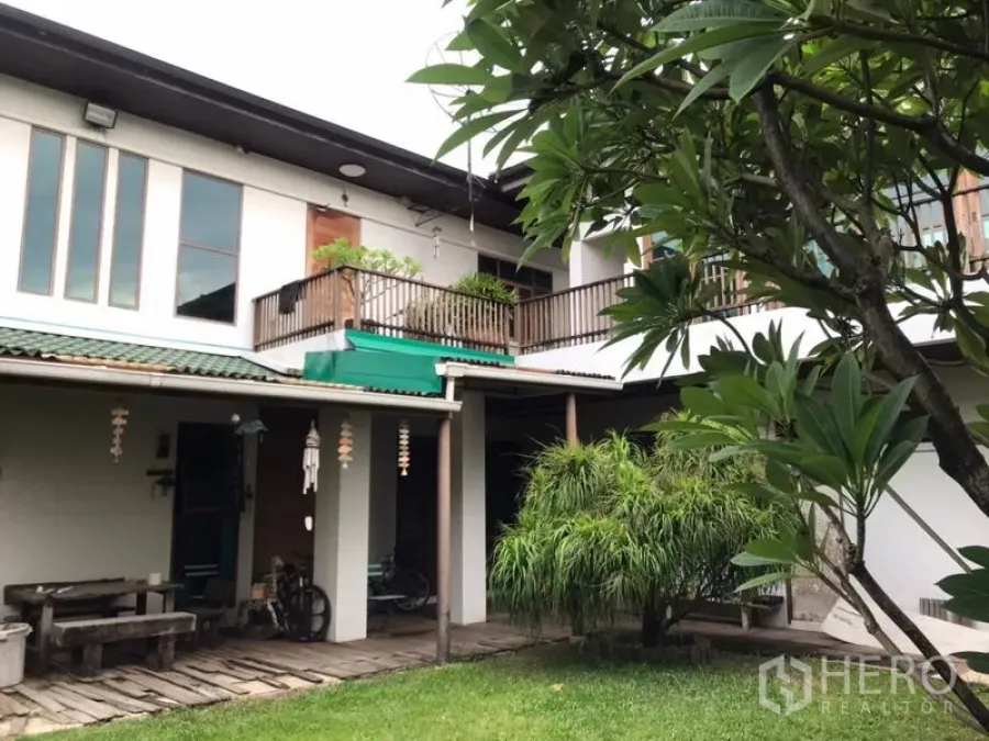 独立式住宅 出售在Lat Phrao, Bangkok - 两层住宅后立面，带阳台、遮蔽露台与景观草坪。