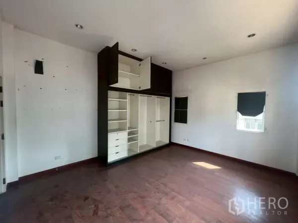 独立式住宅 出租在Watthana, Bangkok - 宽敞卧室，木地板、白墙，配内置衣柜。