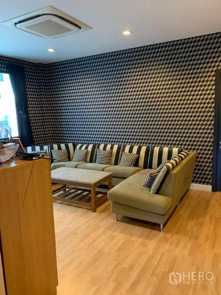 ทาวน์เฮาส์ ให้เช่าหรือขายในChatuchak, Bangkok - ห้องพักผ่อนพร้อมโซฟาเข้ามุม พื้นไม้ และผนังลายกราฟิก