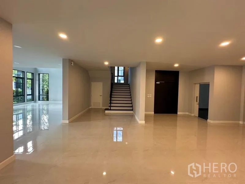 Detached House for rent or sale in Bang Phli, Samut Prakan - Open-plan ground floor with a central staircase and glossy tile flooring.