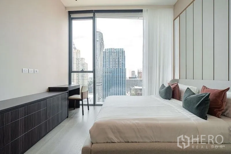 Condominium for rent - Bedroom angle showing built-in desk and storage facing city skyline.