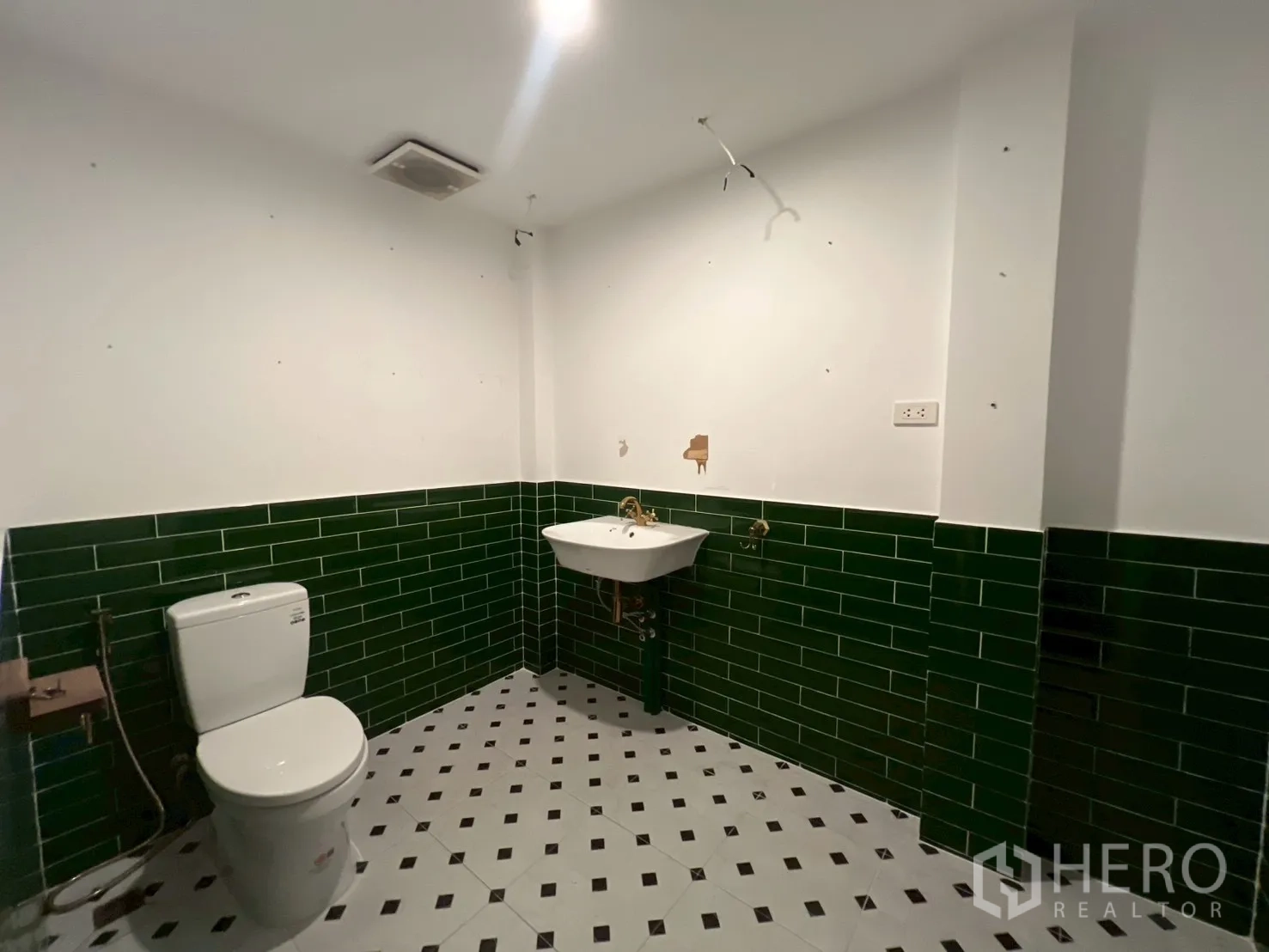 Office Space for rent in Watthana, Bangkok - Spacious restroom with green subway tiles, patterned floor, toilet and wall sink.