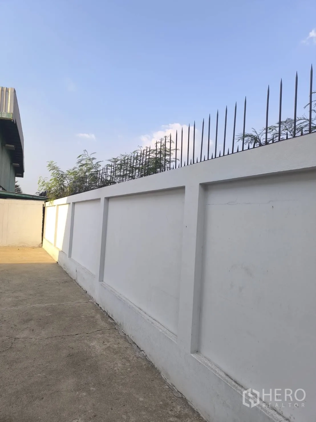 Factory for sale in Khlong Luang, Pathum Thani - Perimeter wall topped with metal security spikes.