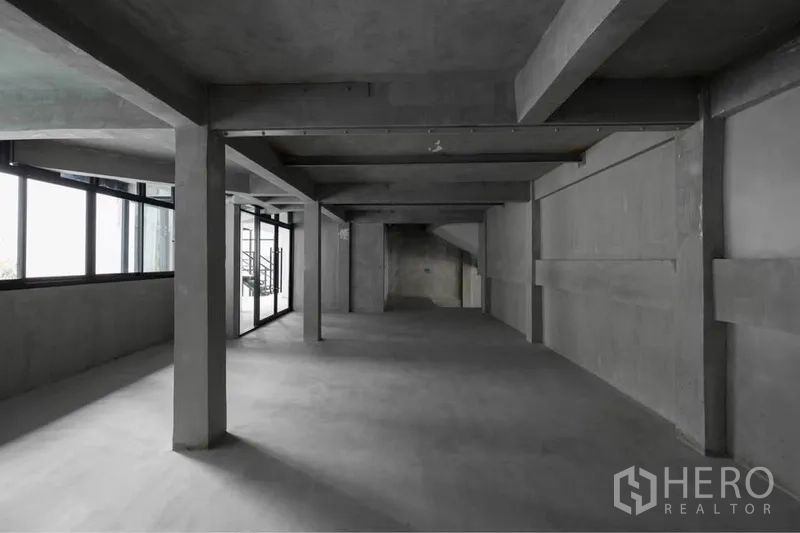 零售空间 出租在Watthana, Bangkok - 宽敞的开放式零售楼层，裸露混凝土梁柱与大面积侧窗，采光充足。