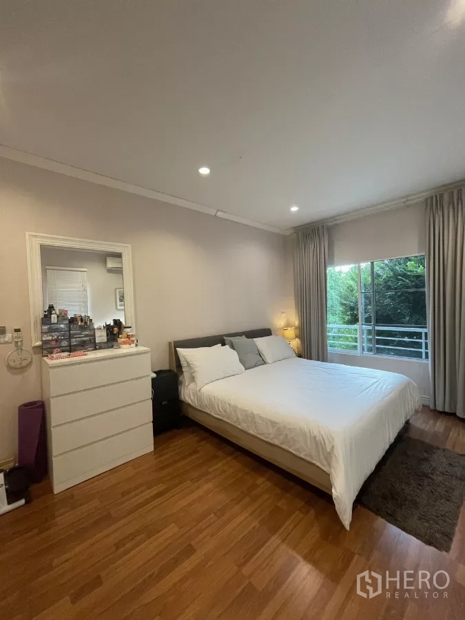 บ้าน ขายในMin Buri, Bangkok - ห้องนอนใหญ่ มองเห็นตู้ลิ้นชักและผ้าม่านเต็มบานประตูระเบียง