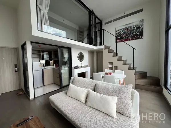 Condominium for rent in Ratchathewi, Bangkok - Another angle of the duplex living room with staircase and enclosed kitchen.