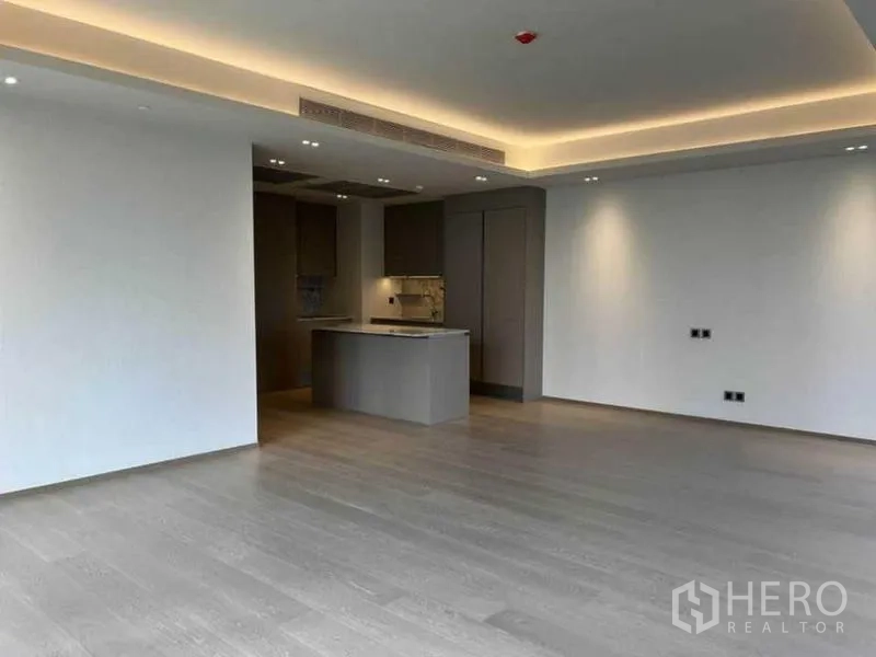 Condominium for rent in Pathum Wan, Bangkok - Spacious open-plan room with kitchen island and recessed ceiling lights.